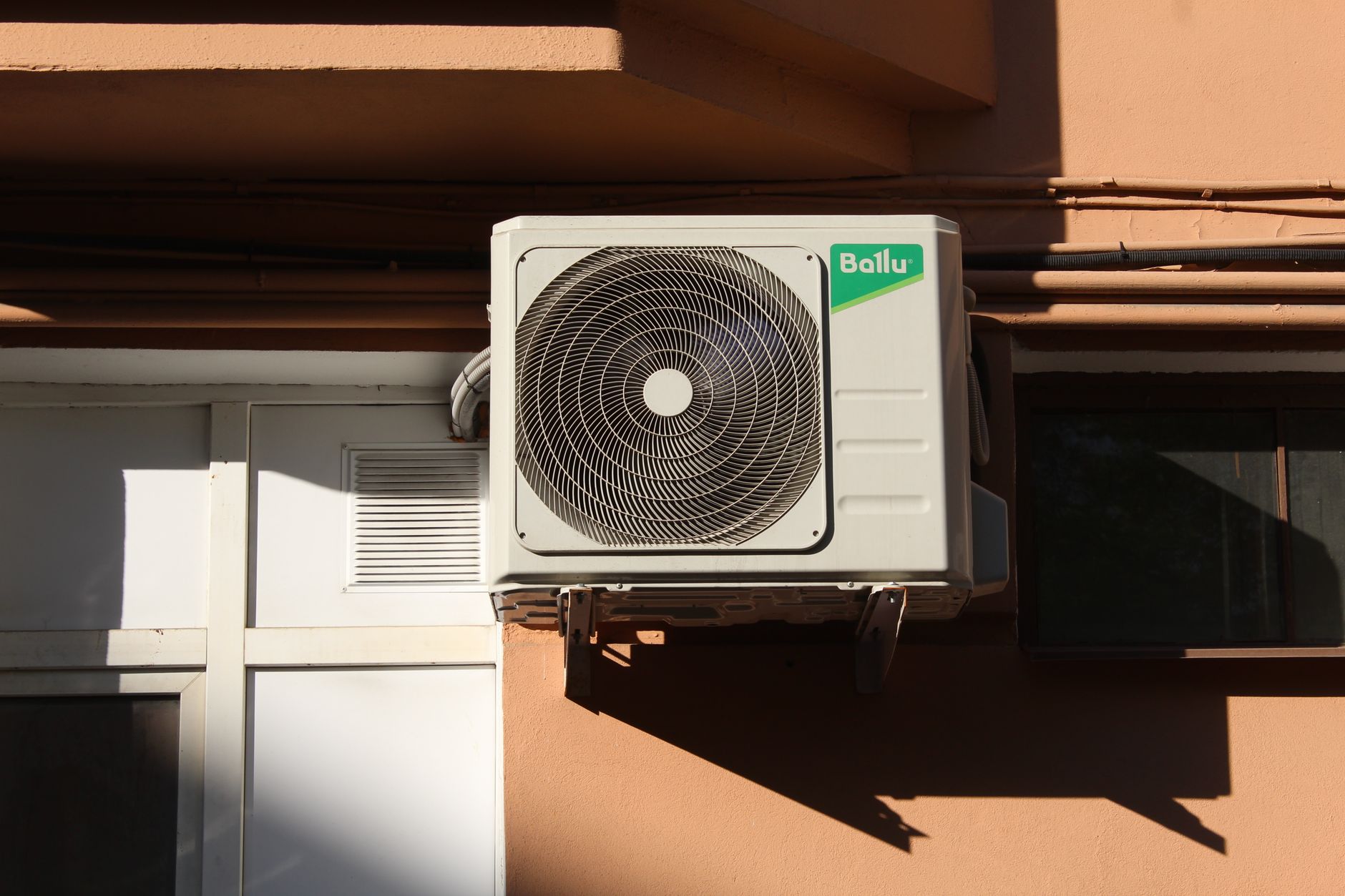 Unité extérieure de climatisation fixée sur des supports muraux en façade